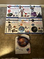 Front view of all six educational books arranged on floor showing titles and covers.