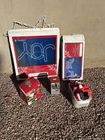 Photo of the packed lighted JOY sign, additional decorative items including a lighted reindeer and sleigh components, and an inflatable elf still in box.