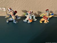 Front view of three Mood Dragon figurines labeled July, August, and September with distinct colors and Swarovski crystals