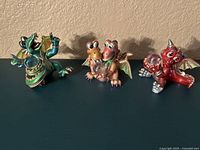 Front view of three Franklin Mint Mood Dragons porcelain figurines with Swarovski crystals, showing color and details.