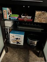 Popcorn maker, molds, Pizzelle baker, muffin pan, cooling racks and griddle packed in cabinet shelf