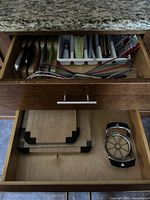 Drawer with kitchen utensils visible including knives, whisks, apple slicer, and wood cutting boards