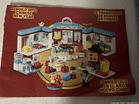 Instruction booklet showing a Chinese New Year themed LEGO Duplo scene featuring decorated rooms, food items, and figurines.