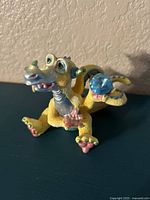 Front and side view of yellow and blue Mood Dragons figurine 'Dippy' with Swarovski crystals on back.