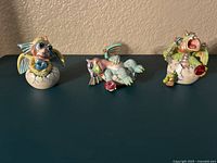 Front view of three pastel-colored Mood Dragons figurines displayed on a table. Each dragon has distinct poses and facial expressions.