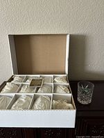 Full box showing twelve individually cushioned old fashioned glasses with one glass out for display.