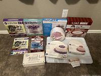 Full layout of cake decorating supplies including turntable, practice boards, and instructional kits by Wilton and Cake Boss.