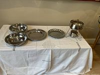 Photo of entire set on white cloth showing two bowls, two plates, and fondue set