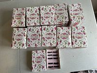 Multiple stacks of floral decorated boxes labeled 'LDIANER false eyelashes' showing unopened packaging and opened box displaying lashes inside