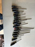 Full view of 14 assorted Mastercraft screwdrivers arranged in two rows on a light surface showing variety of sizes and types.