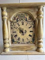 Front view of rectangular wooden wall clock with decorative floral and bird motifs on dial