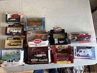 Top-down view of all 10 boxed diecast vehicles arranged on a table, showing boxed condition and packaging designs.