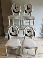 Four chairs arranged two on a table and two on the floor showing front view.