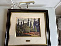 Overall overhead shot of framed painting on table with light fixture above