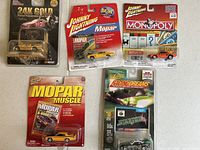 Photo showing the five Johnny Lightning diecast cars in original packaging on a white surface.