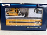 Front view of the Penske 1/53 diecast tractor trailer in original packaging showing yellow cab and trailer with branding.