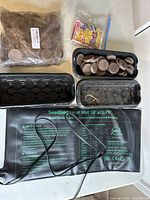 Seedling starter kit contents including black trays, peat pads, heat mat with printed instructions, and vegetable seeds.