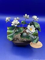 Front angle of vintage Bovano enameled flowers on copper and their planter base with leaves and flowers visible.