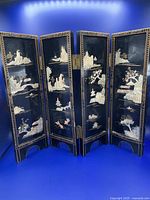 Photo showing both four-panel Chinese wood lacquer table screens fully unfolded, landscape side with mother of pearl inlay featuring rocks, trees, water and pagodas inlaid on black lacquered wood, gold-painted decorative edges.