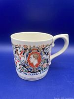 Full side view showing portrait of King Edward VIII with decorative royal emblems and floral designs, white ceramic body, curved handle, in very good vintage condition.