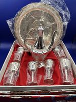 Boxed decorative Chinese tea set with tray, teapot, and six tea glasses wrapped in plastic inside box with red lining