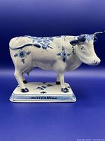 Full side profile of Delftware cow figurine on base