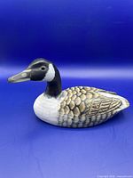 Full side view of the hand painted Canada goose decoy showing shape and coloration.