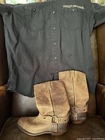 Full view of Harley Davidson black shirt and Boulet brown leather motorcycle boots showing condition of both items.