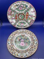Two detailed shots of one plate showing the intricate Famille Rose hand-painted decoration with flowers, birds, and traditional figures in vibrant colors.