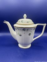 Full view of the white porcelain coffee pot with floral pansy pattern and gold trim on handle, spout, and lid.