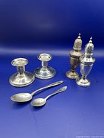 All six items together against a blue background, showing candlesticks, salt shakers and spoons.