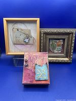 Three mixed media art pieces arranged on a blue background, showing size and framing differences and texture details.