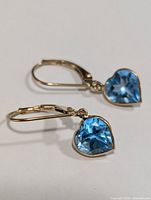 Pair of heart-shaped blue topaz dangle earrings in 10K gold, front view