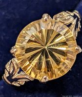 Close-up front view of round faceted citrine and prong setting