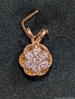 Close-up front view showing the floral cluster of lab diamonds set on a 14K yellow gold scalloped base pendant.