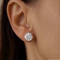 Close-up of moissanite stud earring worn on an ear showing size and appearance.