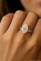 Pear-shaped center stone on finger showing scale and style