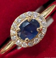 Oblique top view of ring showing oval blue sapphire and surrounding moissanite halo