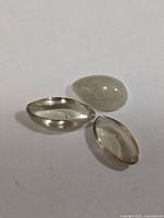 Close-up image showing three loose polished Zultanite gemstones on a white background.