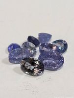 Closeup of assorted tanzanite gemstones showing color and faceting detail.