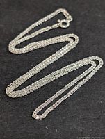 Full view of the silver chain necklace laid out showing length and clasp.