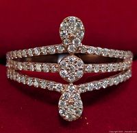 Front view of the rose gold-tone silver ring with sidewalks of Moissanite stones and cluster design featuring pear and round shaped stones.