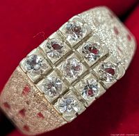 Close-up front view of the silver ring showing nine clear stones set in a 3x3 pattern with textured band.