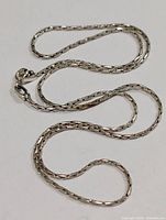 Sterling silver chain necklace laid out to show overall length and box link design.