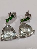 Pair of silver earrings with triangular faceted green amethyst stones and three smaller round chrome diopside stones each, shown on a white background.