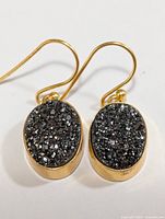 Front view of gold-tone oval Druzy earrings with textured sparkle surface and French hook closure.