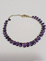 Full view of the silver bracelet showing the amethyst teardrop stones and clasp.