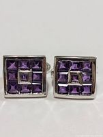 Front view of pair of square sterling silver earrings with nine purple amethyst stones arranged in a grid pattern.