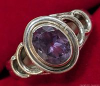 Close-up front view of the silver ring with oval faceted amethyst stone, showing the gemstone's color and the silver loop design on the band.