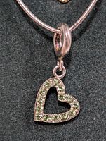 Close-up photo showing the silver heart pendant with cubic zirconia details, attached to the silver snake chain.